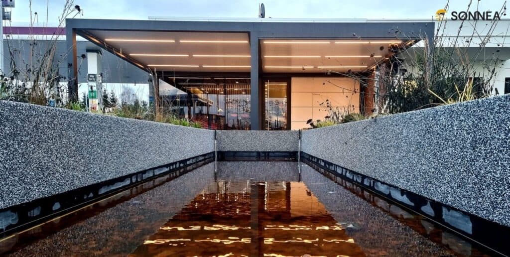 Pergola lamelowa z oświetleniem oraz roletami na stacji benzynowej